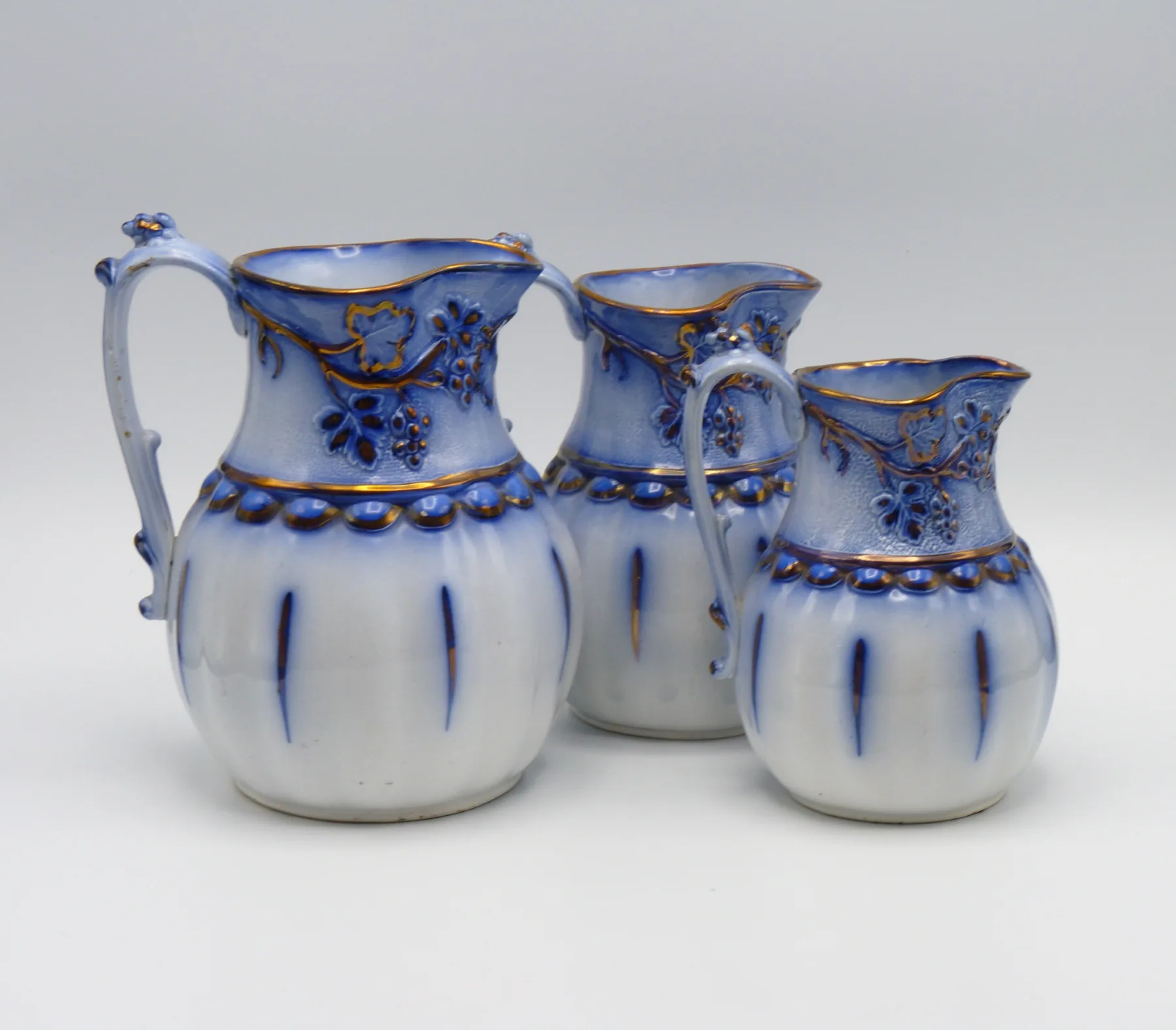 3 Graduating Flow Blue & Copper Lustre Relief Moulded Jugs